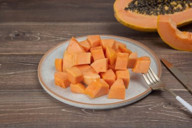 Sliced ripe papaya fruit on plate with fork ready to eating, Tropical fruit.