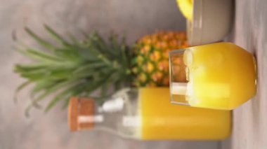 Rum cocktail with pineapple juice. Barman decorating with pineapple slice a cocktail. Vertical Video