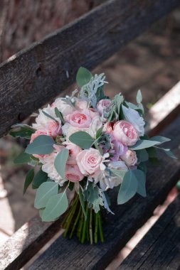 Pink bridal bouquet with ribbons. Wedding bouquet composed of roses and eucalyptus