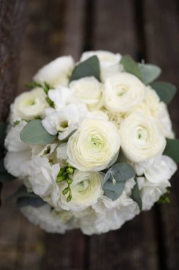 Wedding bouquet of white flowers - ranunculus, freesia, lisianthus.. Bride and groom. Wedding Dress