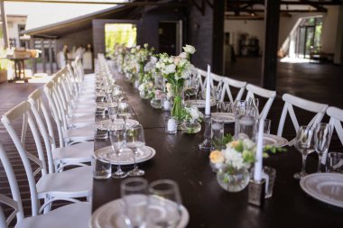 Çok güzel dekore edilmiş bir düğün masası randevusu. Baharın bahçesinde tabaklar ve peçetelerle süslenmiş güzel bir dekor. Düğün günü masada güzel çiçekler. Zarif yemek masası. Düğün günü.