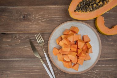 Sliced ripe papaya fruit on plate with fork ready to eating, Tropical fruit, Top view