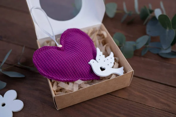 Fabric purple heart on wooden table background. Giff idea.