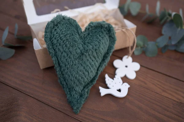 Fabric green heart on wooden table background. Giff idea.