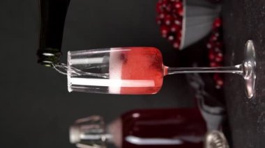 Vertical Screen. Cranberry mimosa cocktail on dark background. Cocktail garnished with sugar and fresh cranberries. Champagne cocktail.