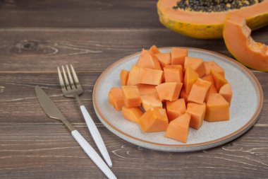 Sliced ripe papaya fruit on plate with fork ready to eating, Tropical fruit.