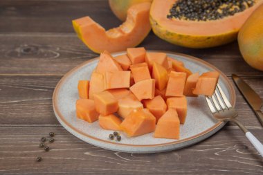 Sliced ripe papaya fruit on plate with fork ready to eating, Tropical fruit.