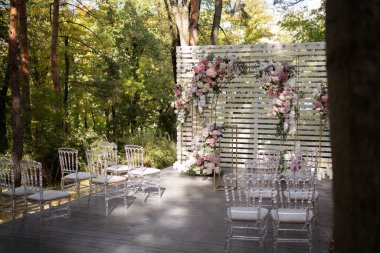 Wedding ceremony. Very beautiful and stylish wedding arch, decorated with various flowers, standing in the garden. Wedding day.