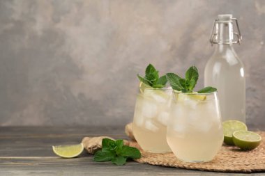 Zencefilli bira, limon ve buzla hazırlanmış taze bir kokteyl. İçecekler masada. Resim metin için kopyalama alanı içeriyor.