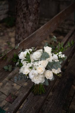 Bir buket beyaz çiçek gül, frezya, lisianthus gelin ve damat. Gelinlik