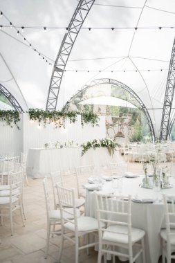 Beyaz ve yumuşak düğün masası düzenlemesi, çiçekli süs. Düğün günü..