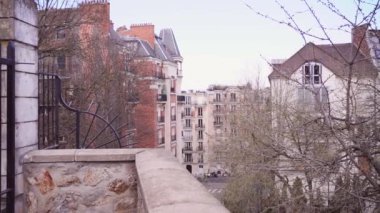 Paris 'in merkezinde eski binalar, çiçek açan ağaçlarla dolu bir sokak. Ağır çekim. Panoramik görünüm.