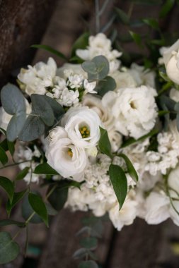 Bir buket beyaz çiçek gül, frezya, lisianthus gelin ve damat. Gelinlik