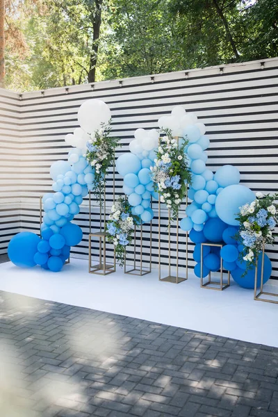 decor with balloons of white, blue and flower arrangemets. Party decorations.