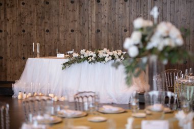 Main table at a wedding reception with beautiful fresh flowers. Wedding day. Fresh flowers arrangements. Wedding with candles and bubble lights.