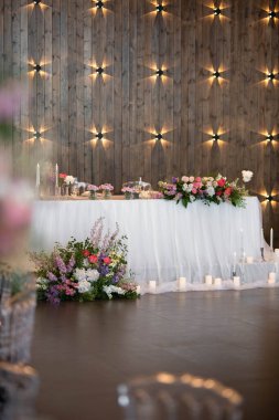 Güzel çiçeklerle dolu bir düğün resepsiyonunda ana masa. Düğün günü. Pembe çiçekli düğün kimlikleri.