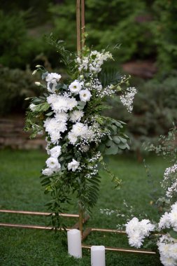 Düğün töreni. Çok güzel ve şık bir düğün kemeri, çeşitli taze çiçeklerle süslenmiş, bahçede duruyor. Düğün günü. Taze çiçek süslemeleri, şakayıklar..