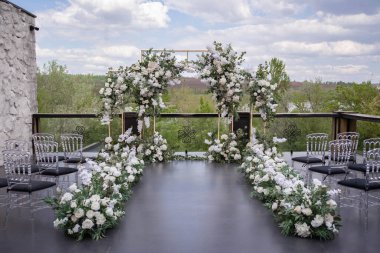 Wedding ceremony. Very beautiful and stylish wedding arch, decorated with various fresh flowers, standing in the garden. Wedding day. Fresh flowers decorations. Wedding day.