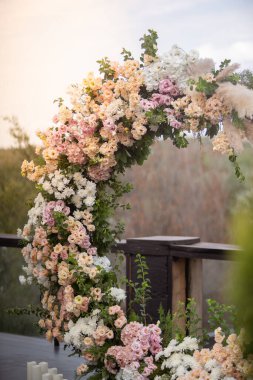 Düğün töreni. Çok güzel ve şık bir düğün kemeri, çeşitli taze çiçeklerle süslenmiş, bahçede duruyor. Düğün günü. Taze çiçek süslemeleri, şakayık düğünleri..