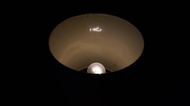 Abajur içinde bir ampul, karanlık bir ortamda aydınlatılmış..