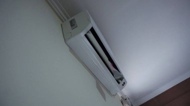 Ön paneli açık olan duvara monte edilmiş klima ünitesi..