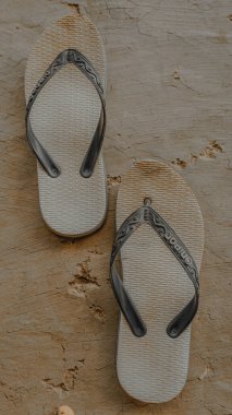 Bir çift yıpranmış parmak arası terlik..