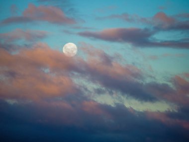 The setting moon in a cloudy sky. Morning