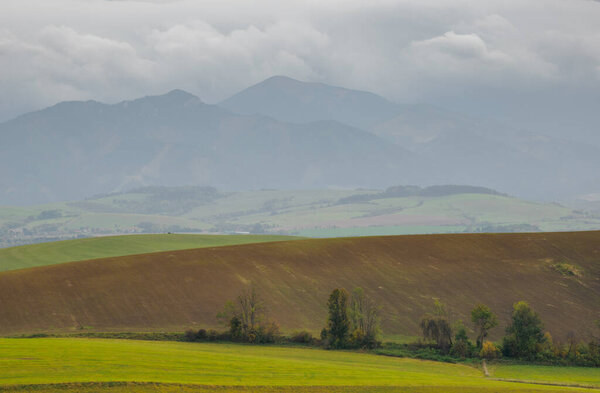 Mountain landscape. In the foreground, a farmland s. In the distance you can see the Low Tatras Zilina Region. Liptovske Matiasovce. Slovakia.