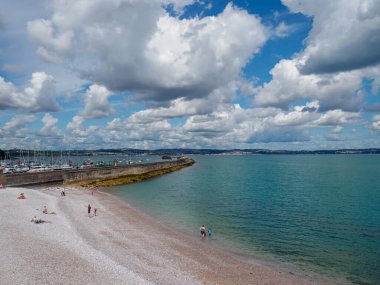 Brixham, Torbay, Devon, Güneybatı, İngiltere, Birleşik Krallık, 07.19.2023. Brixham Kırıksu Sahili. Kumsal ve dalgakıran manzarası. Deniz Burnu. Güneşli bir günde kumsal ve dalgakıran manzarası.