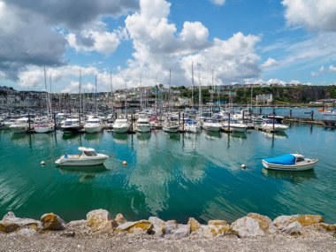 Brixham, Torbay, Devon, Güneybatı, İngiltere, Birleşik Krallık, 07.19.2023. Brixham Swing Moorings, güneşli bir günde küçük bir liman manzarası. Yaz. Demirlemiş yatlar ve motorlu tekneler. Yat limanının manzarası,