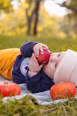 Yüksek sandalye yeme elma meyve içinde oturan sevimli sevimli gülümseyen gülen beyaz çocuk kız çocuk portresi. Günlük yaşam tarzı. Gerçek otantik tatlı ev an