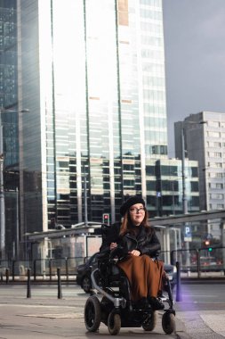 Şehir caddesinde tekerlekli sandalyede oturan esmer kadın. Yüksek kalite fotoğraf