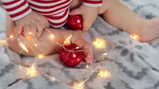 可愛い赤ちゃんはクリスマスライトで遊ぶ — ストック動画