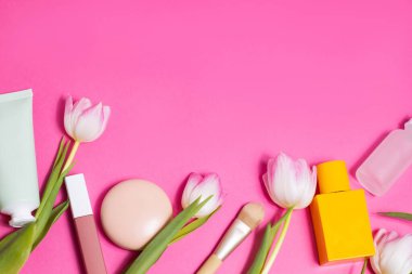 Beauty background with natural cosmetic, green leaves and flowers. Flat lay image on blue. High quality photo