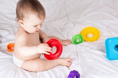 Renkli gökkuşağı oyuncak piramidiyle oynayan şirin bir bebek. Küçük çocuklar için oyuncaklar. 