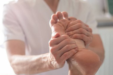 Fizyoterapist ayak masajı yapıyor.