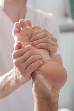 Fizyoterapist ayak masajı yapıyor.