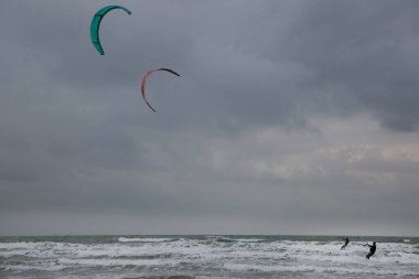 İnsanlar denizde rüzgar sörfü yapıyor.