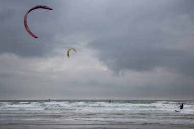 İnsanlar denizde rüzgar sörfü yapıyor.