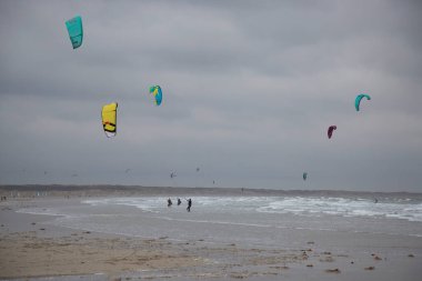 İnsanlar denizde rüzgar sörfü yapıyor.