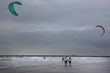 İnsanlar denizde rüzgar sörfü yapıyor.