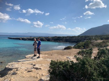 Kayalık deniz kıyısında turistler