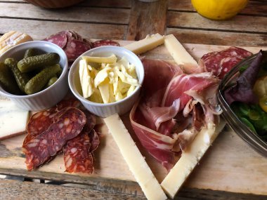 Peynir, jambon turşusu ve tahta üzerinde salatalık.