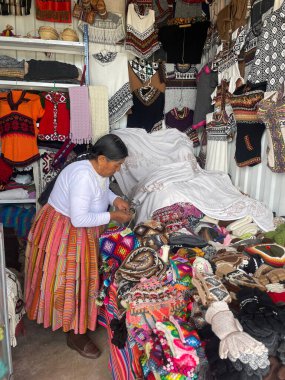 Peru - 30 Aralık 2023: Perulu kadın pazarda el işi satıyor.