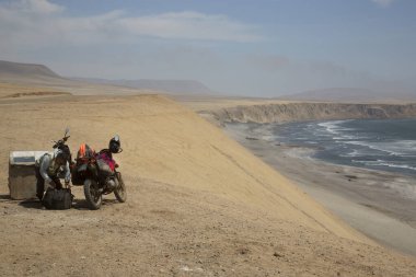 Deniz kıyısında motosikletli erkek turist manzarası