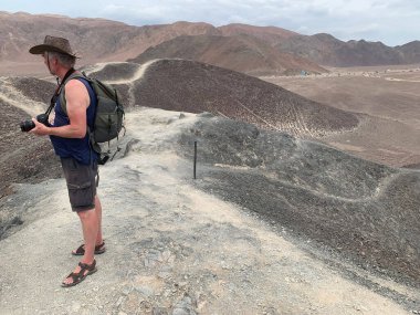 Sırt çantalı bir adam dağın tepesinde.