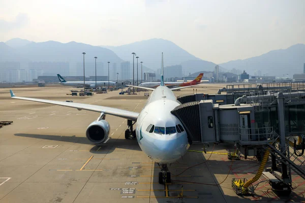 stock image Hong Kong - March 1, 2023: Airplane at boarding gate jet bridge in Hong Kong international airport. The airport code is HKG.