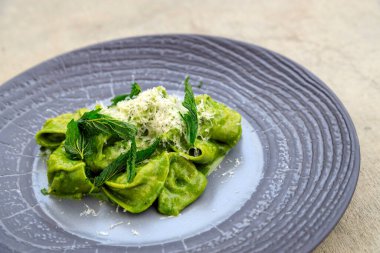 El yapımı makarna. Parmesan peynirli ısırgan otu ve ısırgan otu soslu öküz kuyruklu tortellini..