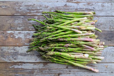 Fotokopi alanı olan eski ahşap bir arka planda bir grup yabani kuşkonmaz düzeneği..