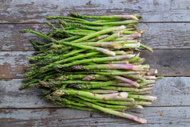 Fotokopi alanı olan eski ahşap bir arka planda bir grup yabani kuşkonmaz düzeneği..